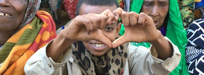Ethiopian child holding fingers in the shape of a heart